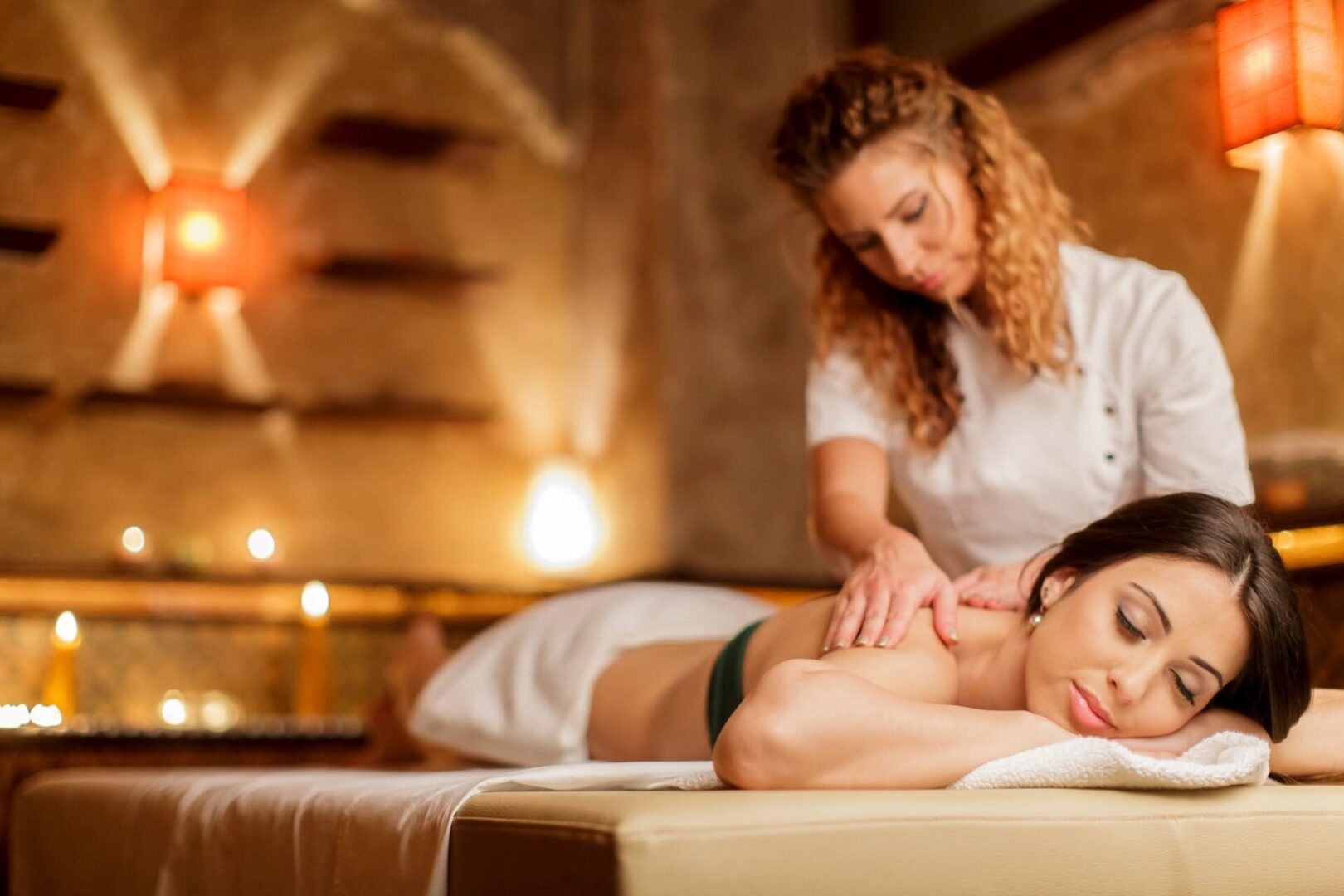 A woman is getting her back massage from a masseuse.